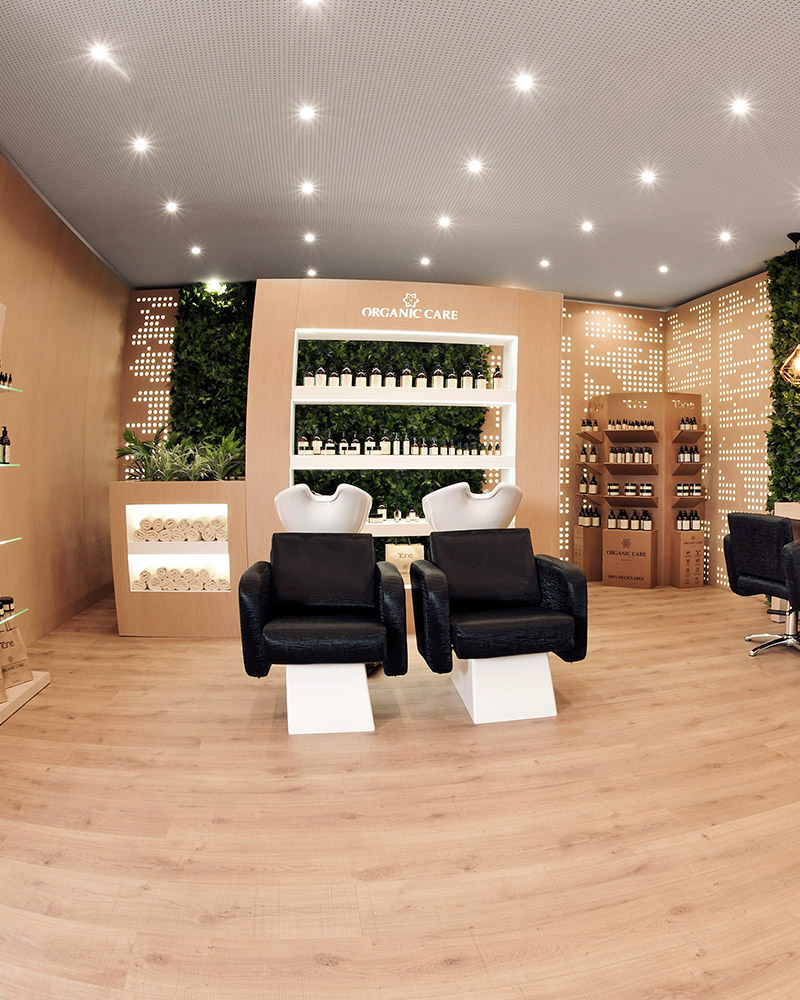Moderne TAHE Organic Care salonruimte met wasstoelen en professionele haarproducten in een duurzame setting.